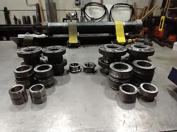 Machined bushings and glands laid out on a bench