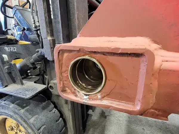 Pin bore in a red equipment arm in the shop